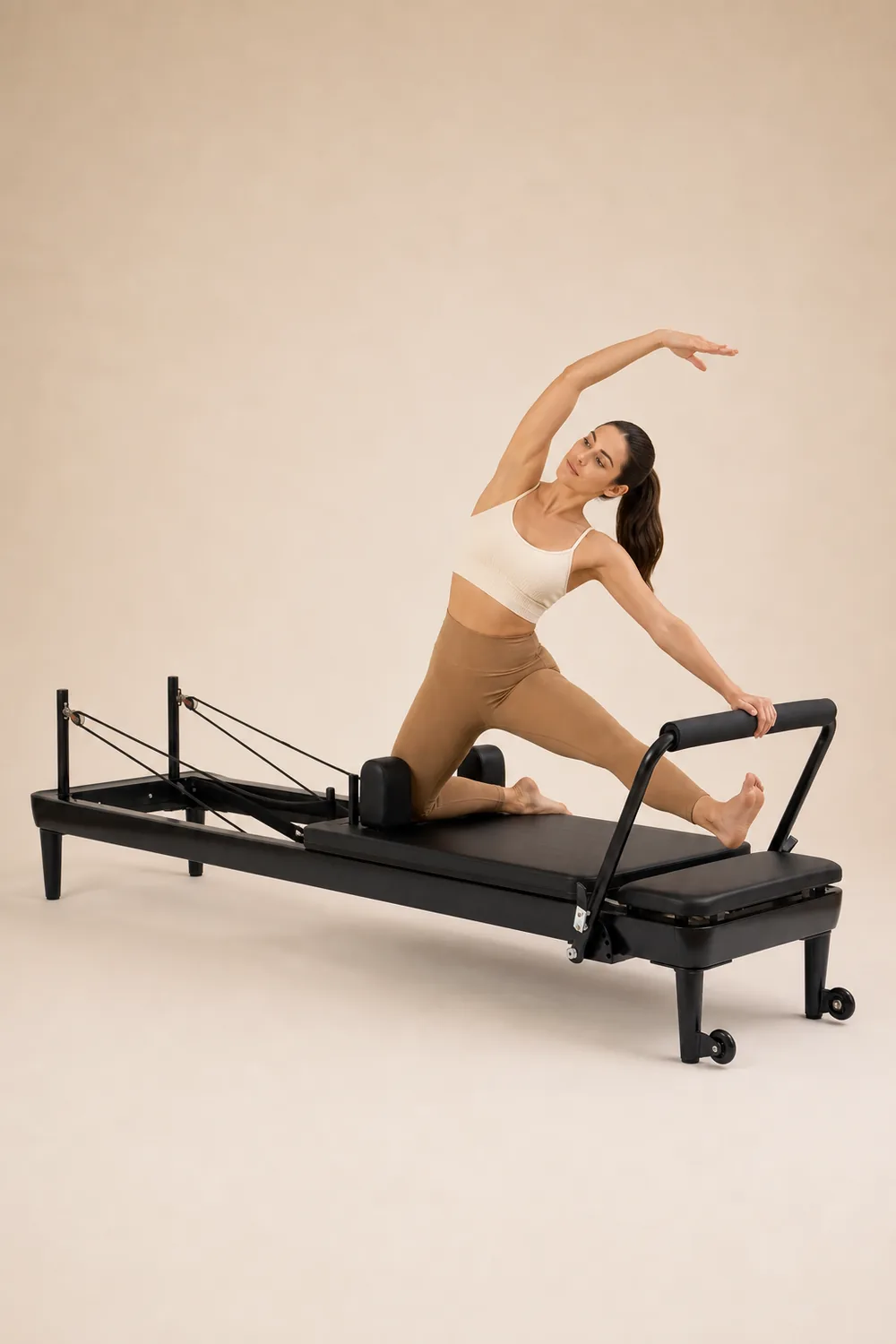 Kontrollált Pilates gyakorlat fekete Nubium Reformer gépen, homogén háttér előtt